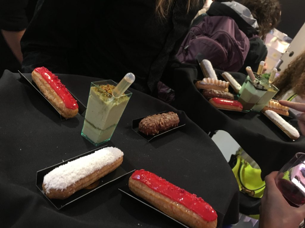 trays of dessert at mini cakes at server with eclair at eclair at macaron at blueberry cheesecake at summer rendezvous at dj at delysee french pastries